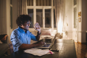 man receiving telehealth services using his laptop