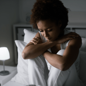 Photo of woman on a bed looking sad