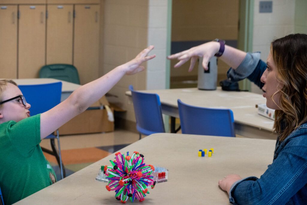 James and his counselor do an exploding fist bump during a school counseling services session.