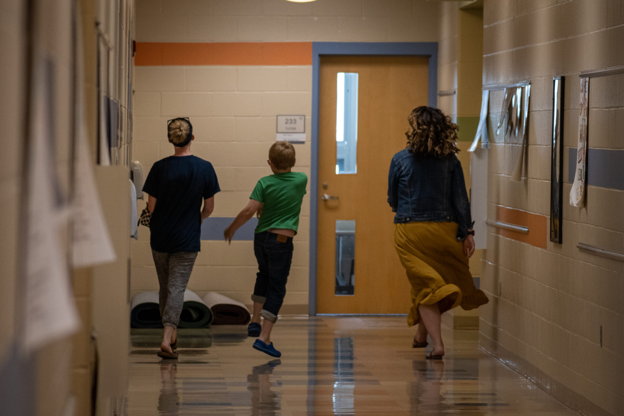 James, his counselor and his mother skip down the hall away form the camera