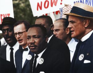 Dr. Martin Luther King Jr. speaks at the podium. King demonstrated impeccable strength, but often this image masks the weight that leadership can have on a person.