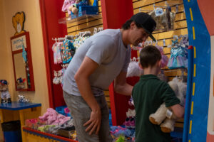 Cal helps a child pick out some clothing options for their bear.