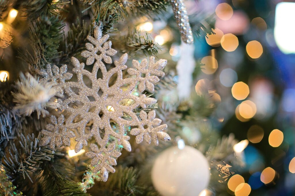 Navigating Holiday Conversations during holiday gatherings. A snowflake ornament sits in a Christmas tree